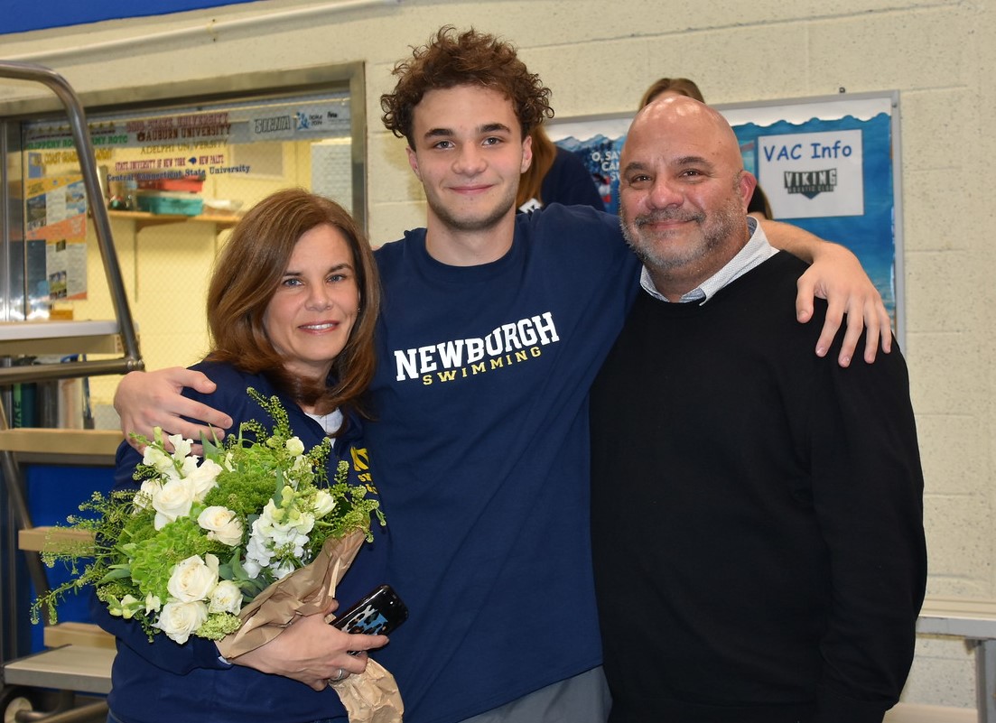 Athlete stands with family for a photo.