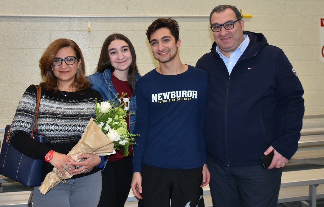 Athlete stands with family for a photo.