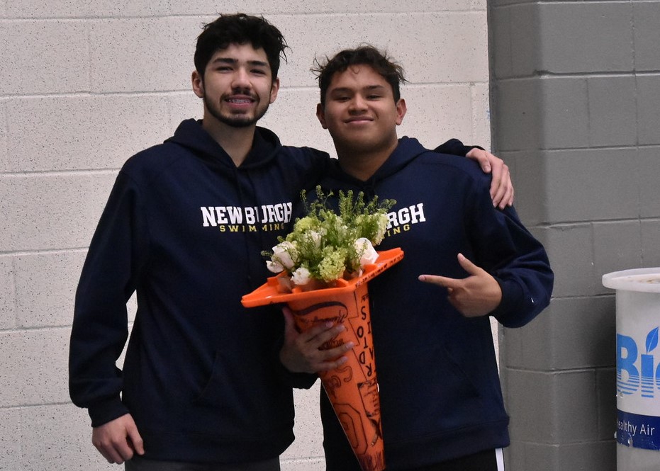 Senior stands with teammates for a photo.