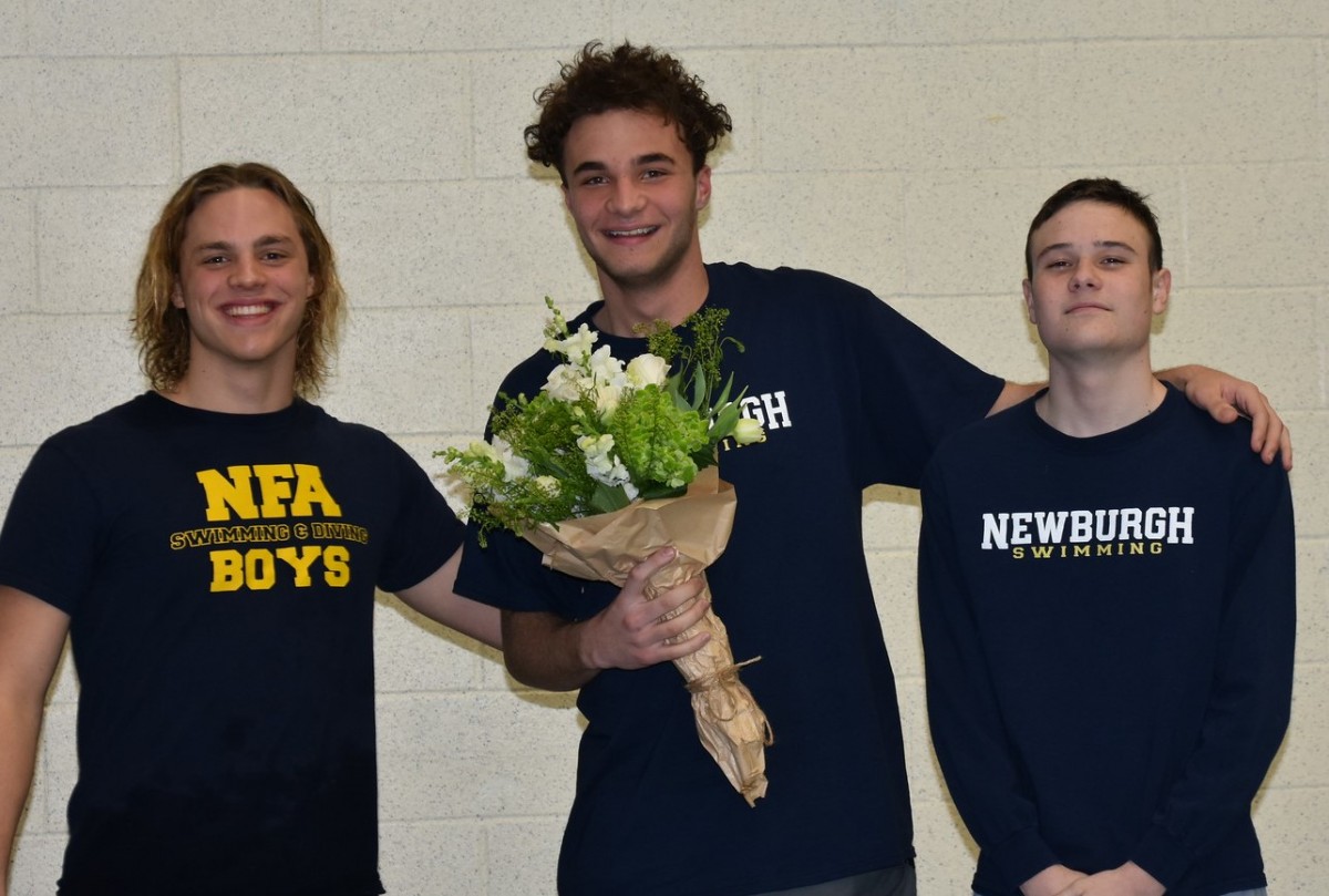 Senior stands with teammates for a photo.