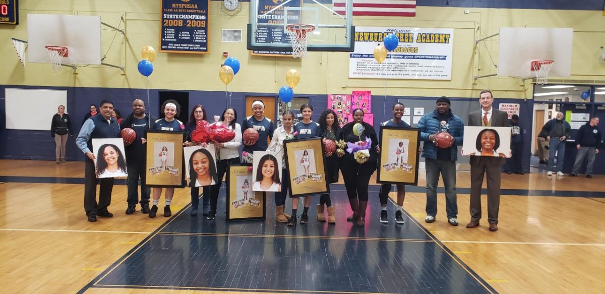 NFA Girls Varsity Basketball seniors pose for a photo with their families.