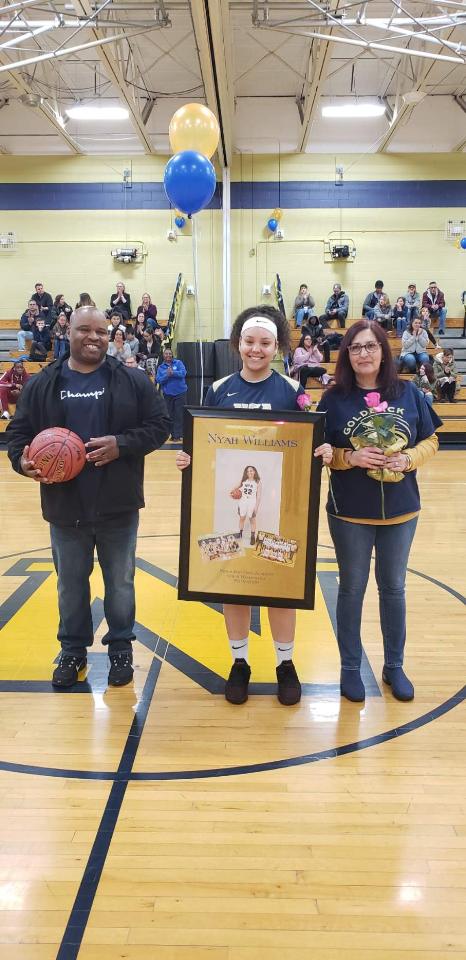 NFA Girls Varsity Basketball senior poses for a photo with her family.
