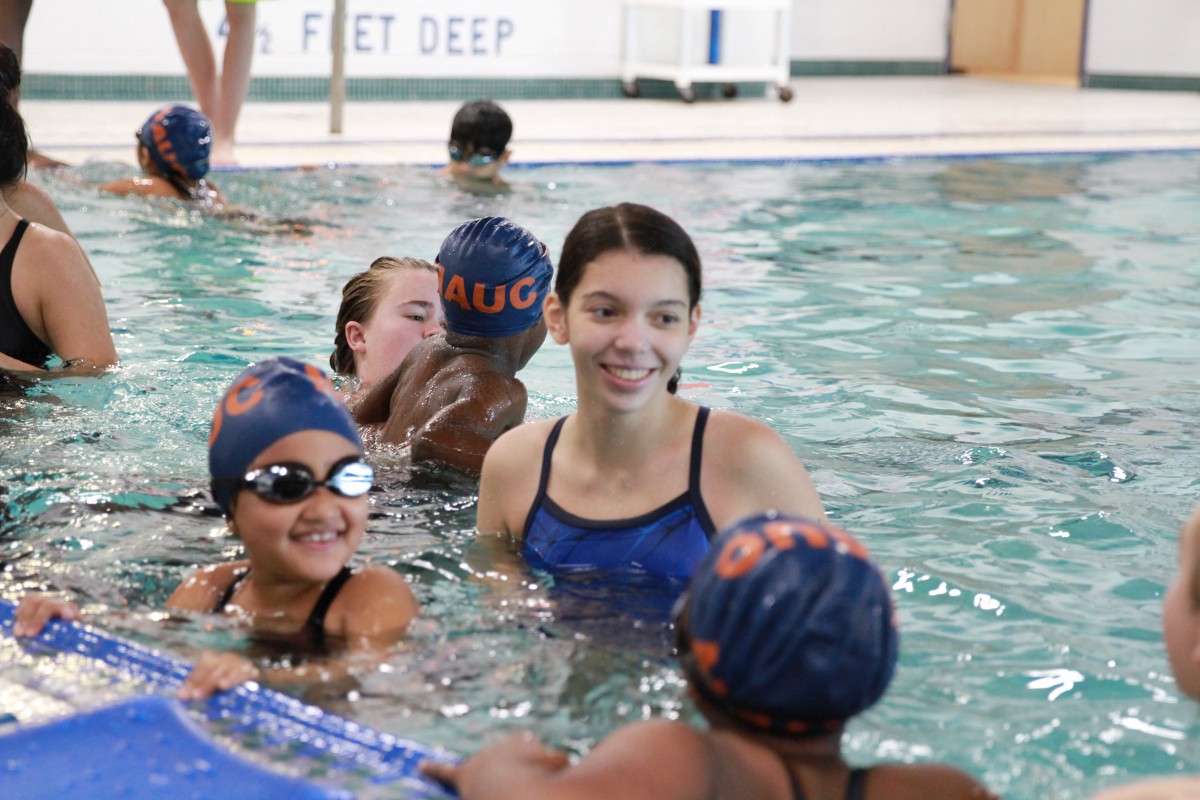 Student teaching child to swim.