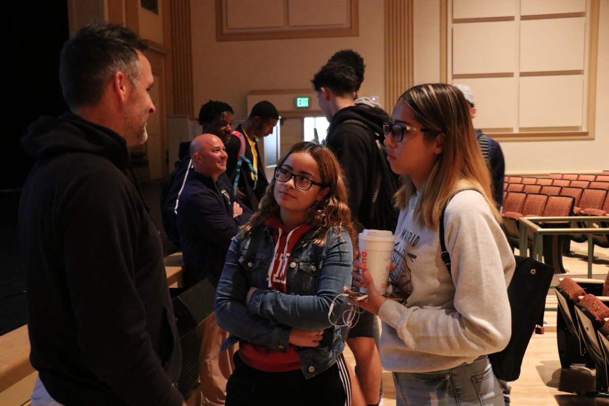 Students speak with the presenter after the program.