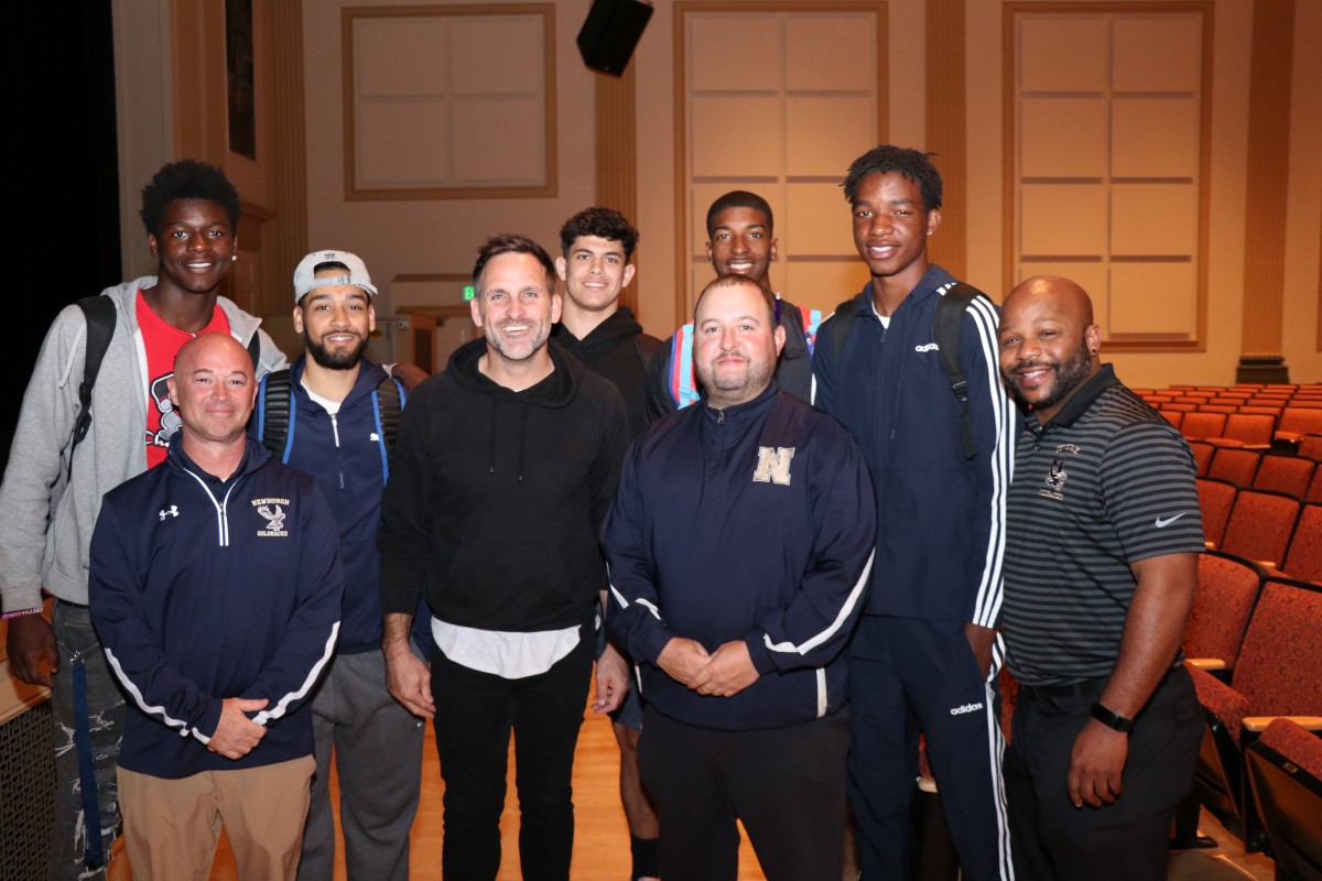 Student athletes pose for a photo with the presenter, Athletic Director, and Director of Physical Education.