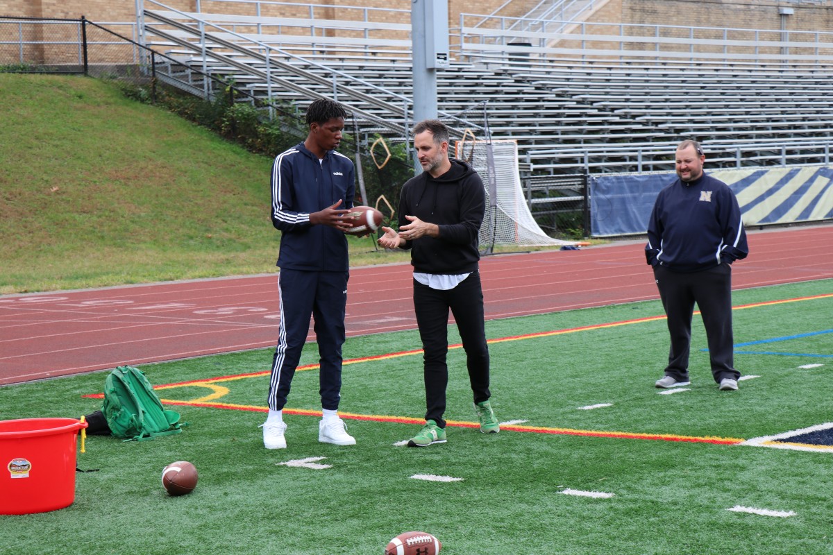 Presenter teaching an athlete a throwing technique.