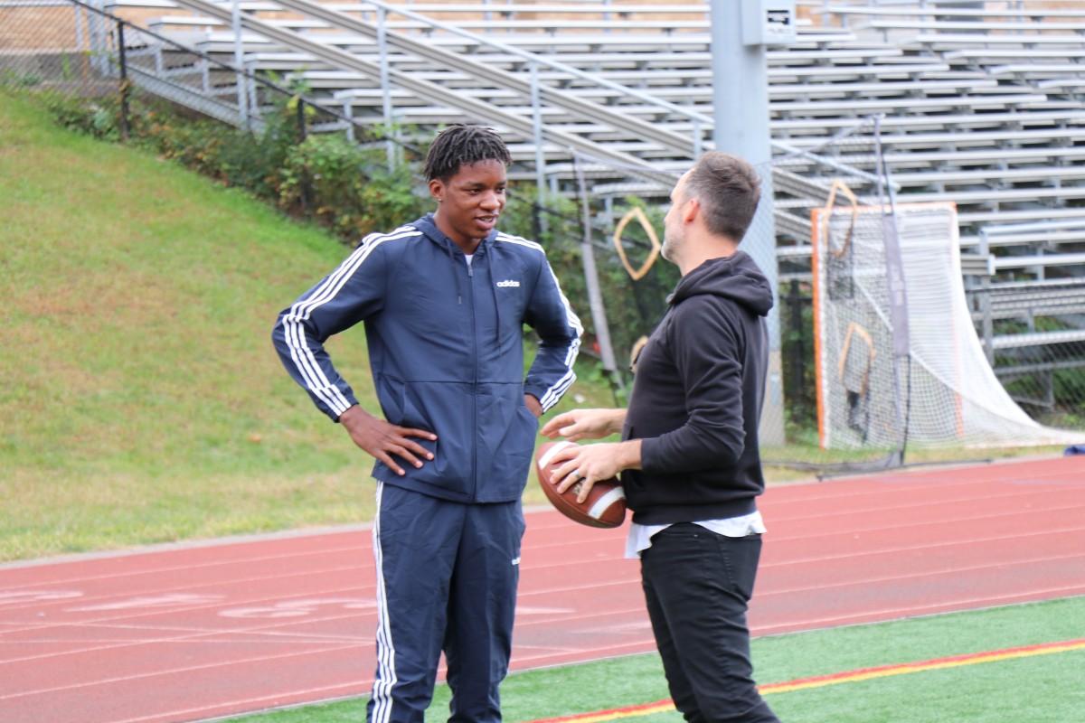 Presenter teaching an athlete a throwing technique.