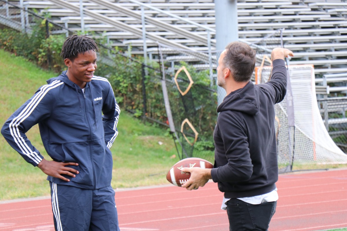 Presenter teaching an athlete a throwing technique.