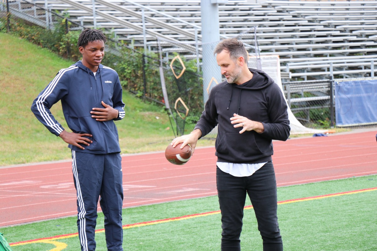 Presenter teaching an athlete a throwing technique.