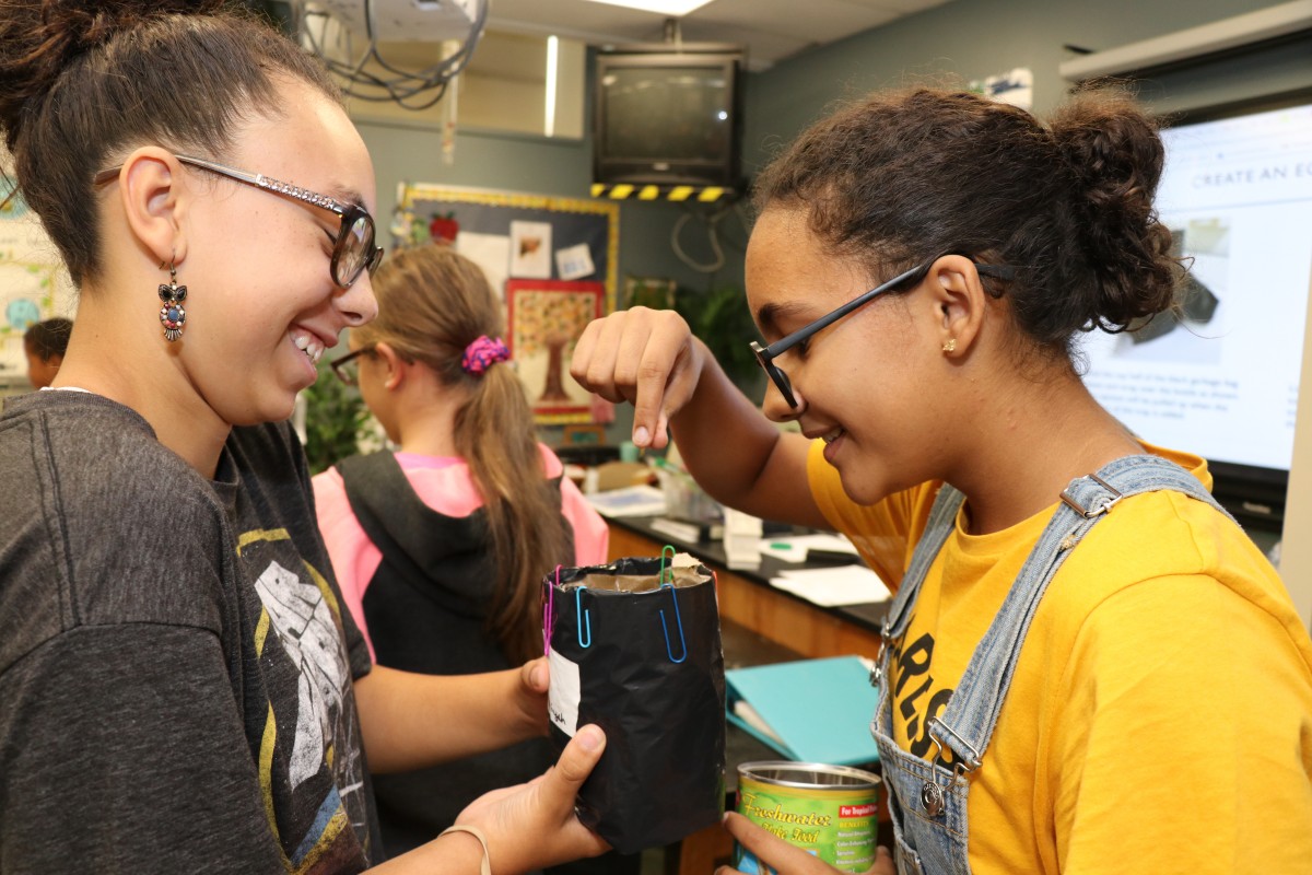 Students add fish food to their trap.