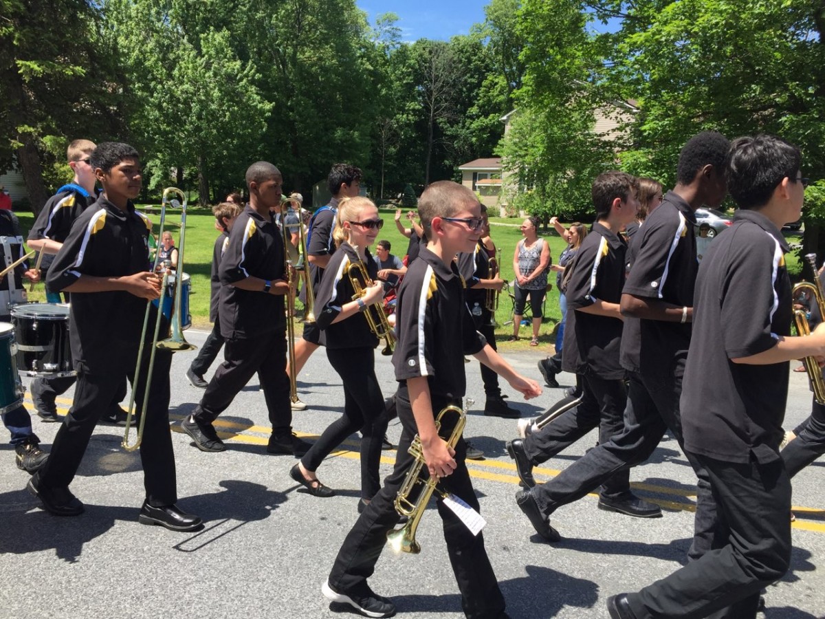 Students holding instruments while they march.