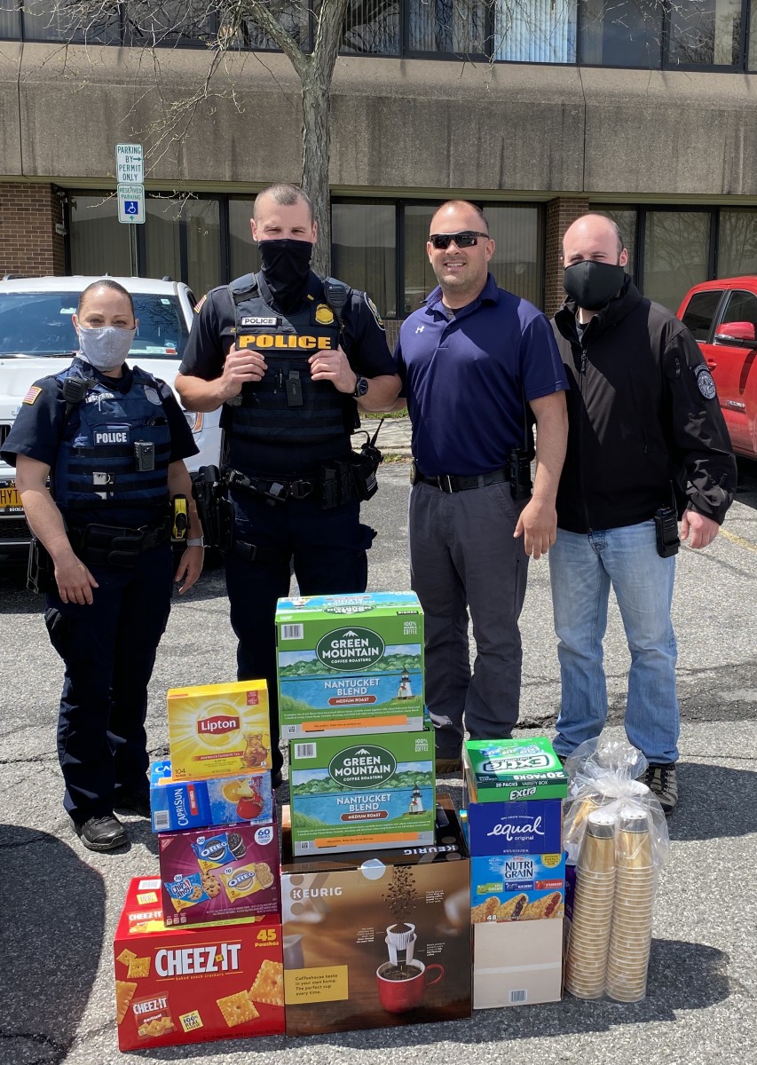 Police officers stand with a pile of donations.