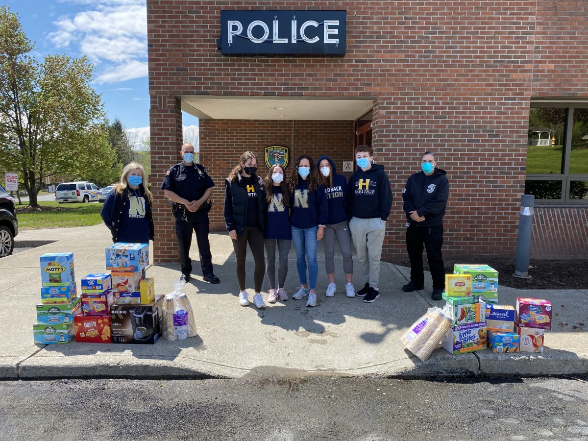 Volunteers stand with donations outside of the Police station.