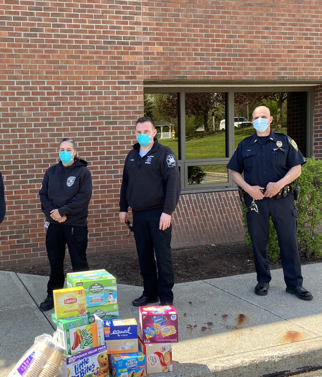 Police officers stand with a pile of donations.