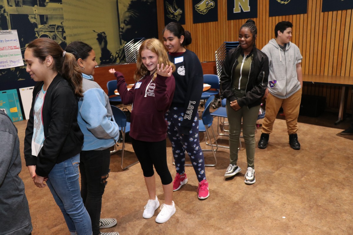 Students participate in a game called Telephone Charades.