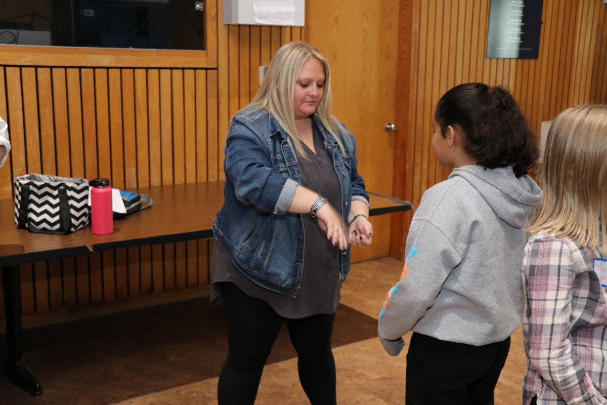 Students participate in a game called Telephone Charades.