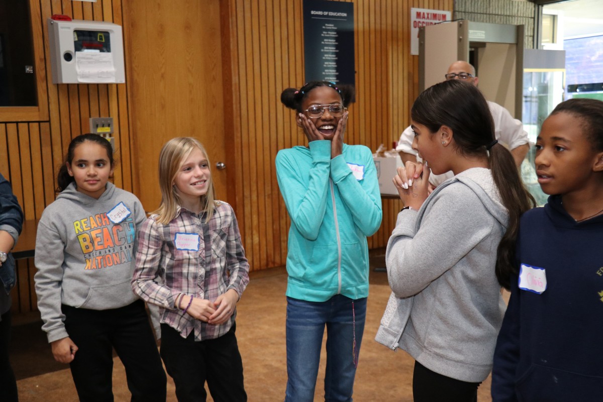 Students participate in a game called Telephone Charades.