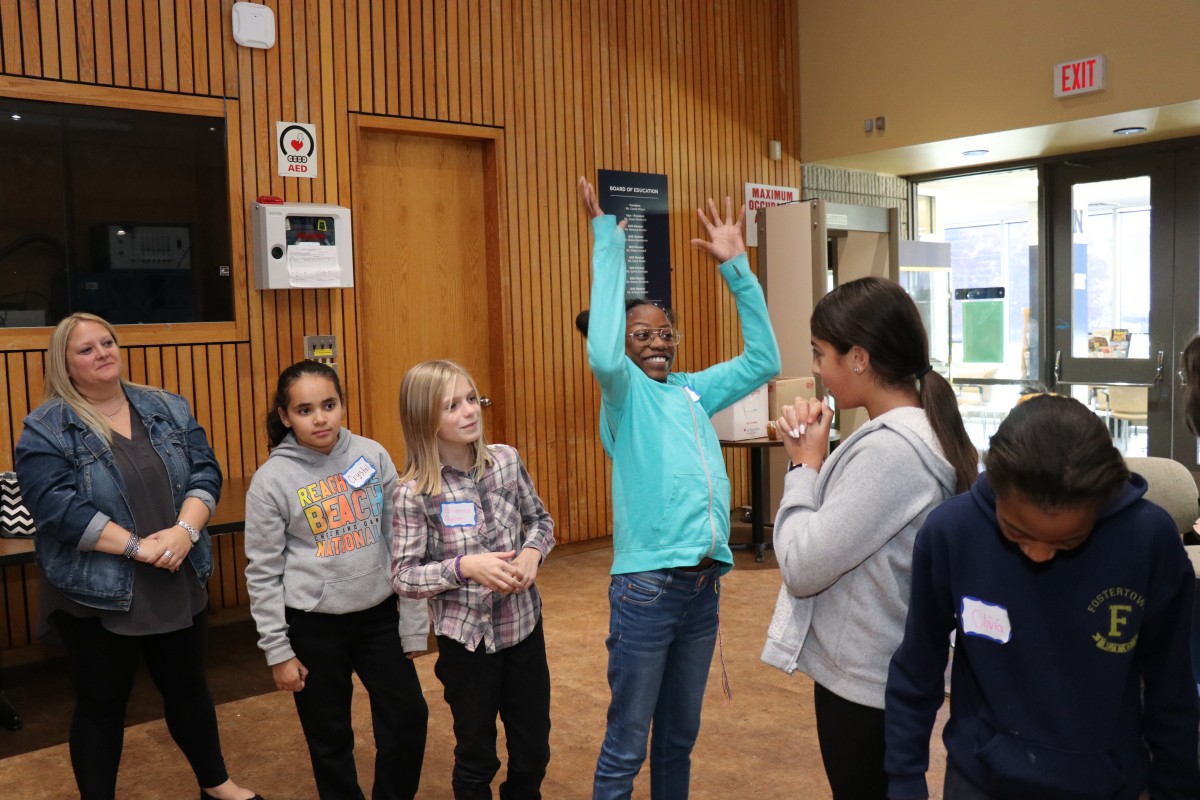 Students participate in a game called Telephone Charades.