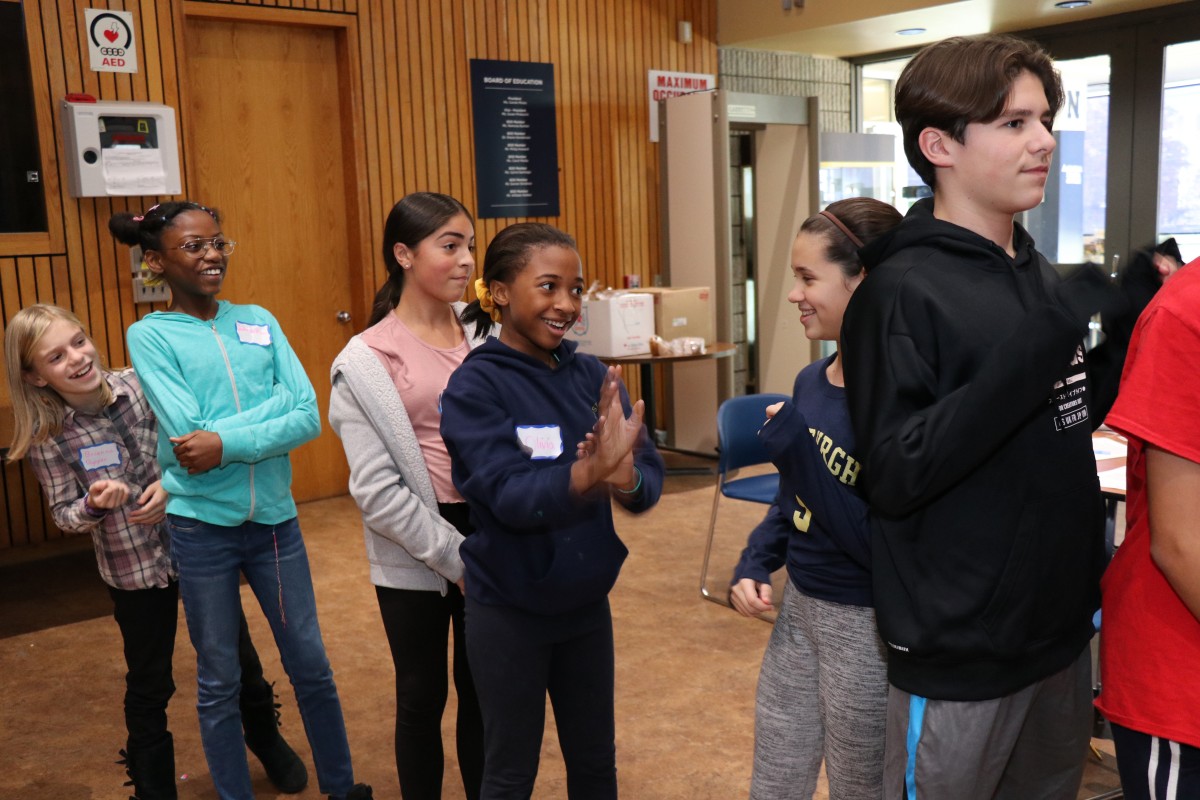 Students participate in a game called Telephone Charades.