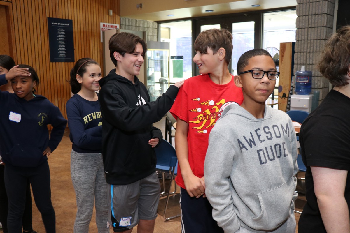 Students participate in a game called Telephone Charades.