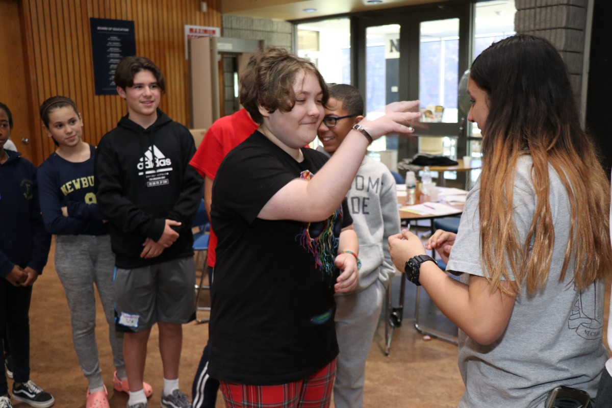 Students participate in a game called Telephone Charades.