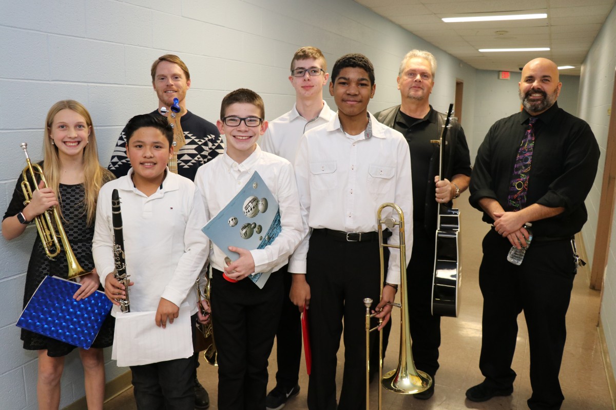 Students and teachers pose for a photo with their instruments.