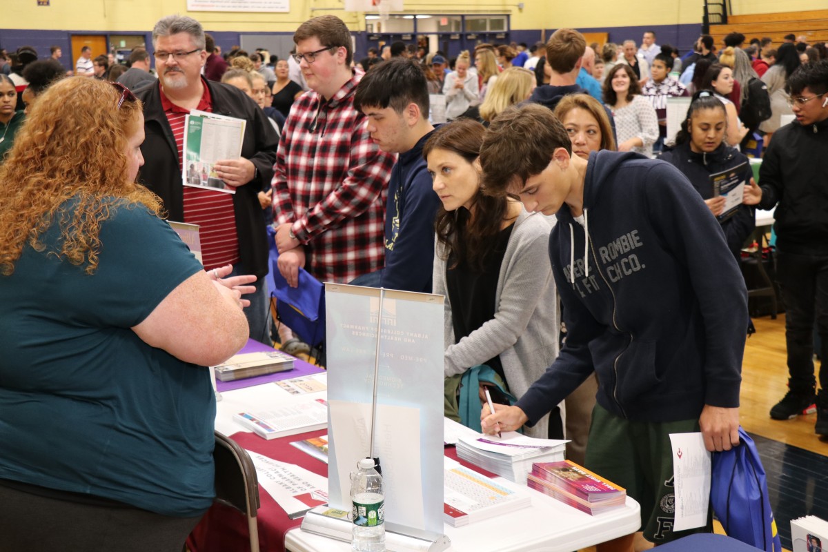 Attendees speak with college admission staff.