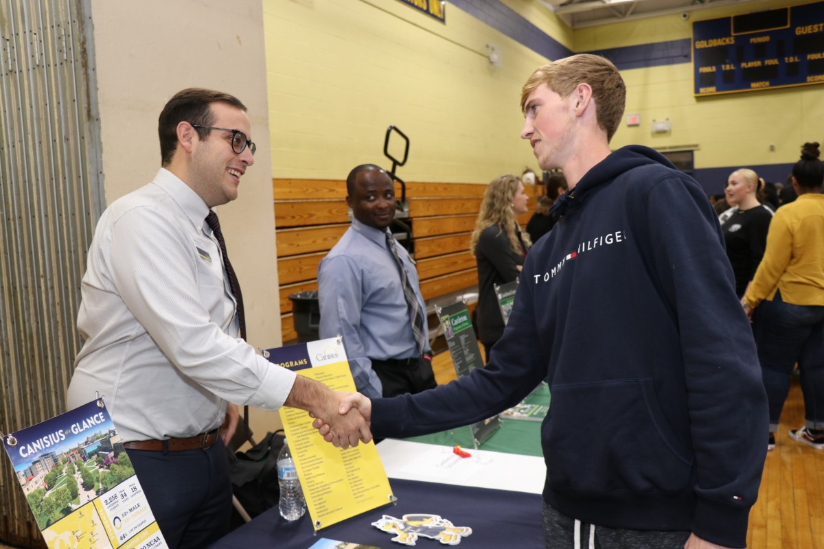 Attendees speak with college admission staff.