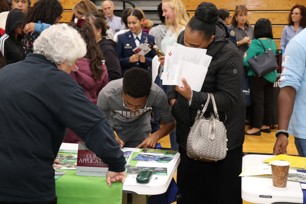 Attendees speak with college admission staff.