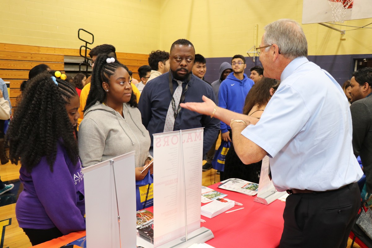 Attendees speak with college admission staff.