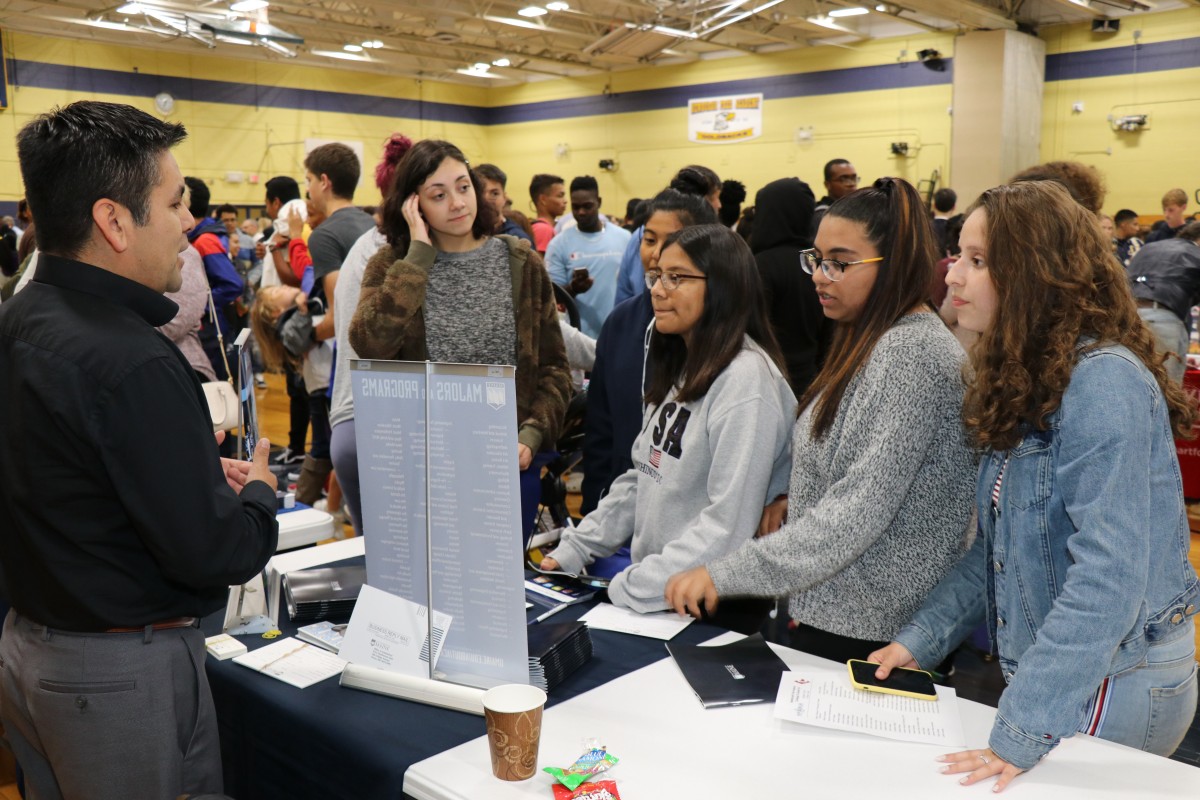 Attendees speak with college admission staff.