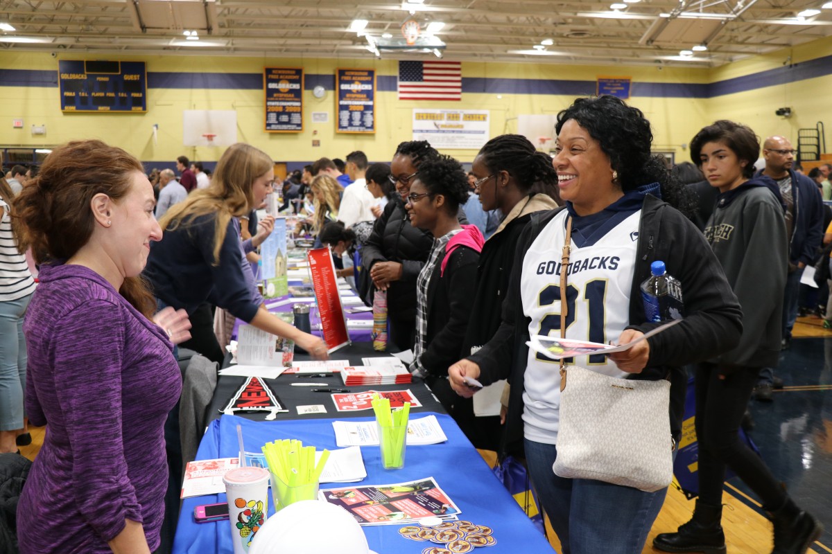 Attendees speak with college admission staff.