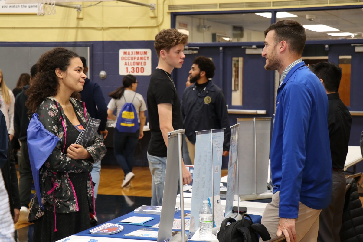 Attendees speak with college admission staff.