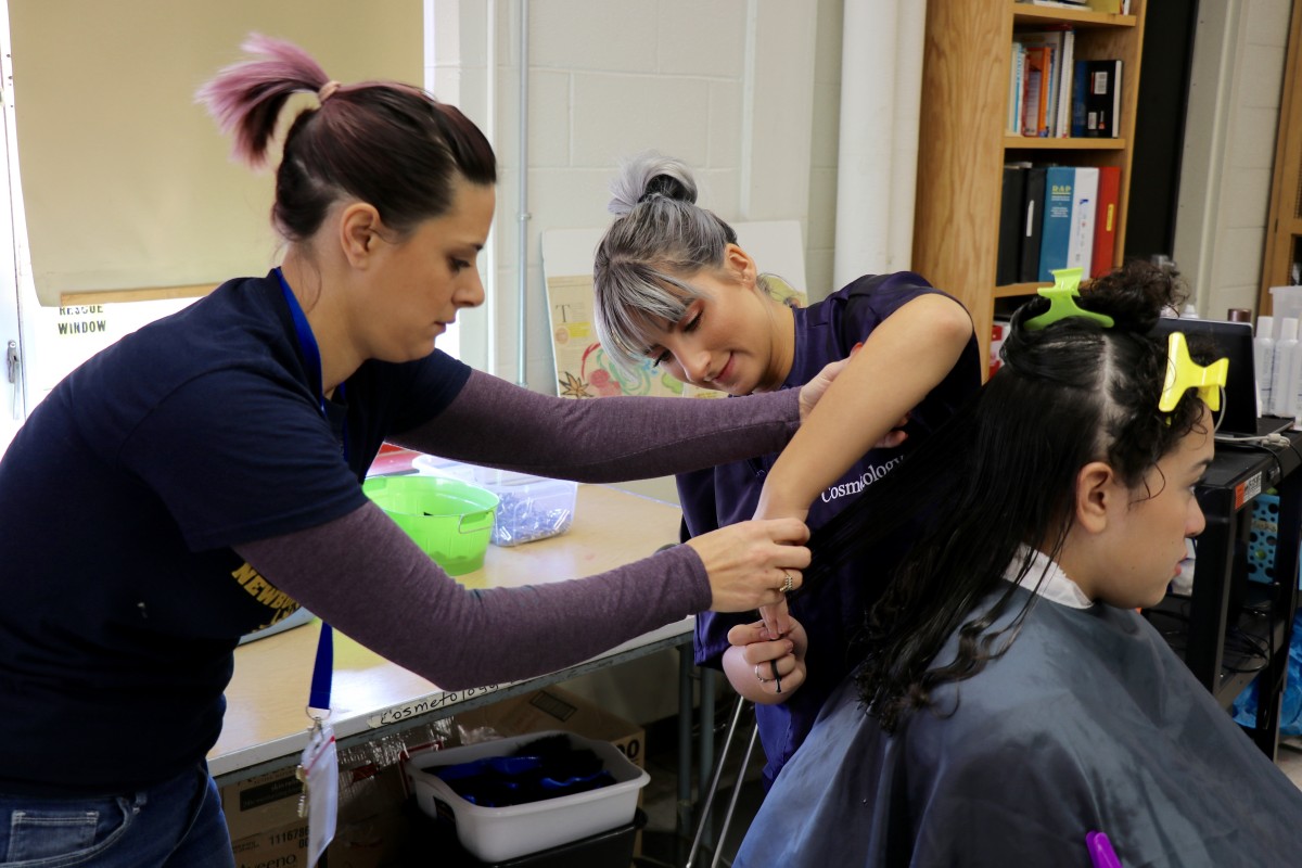 Teacher helps students perfect technique.