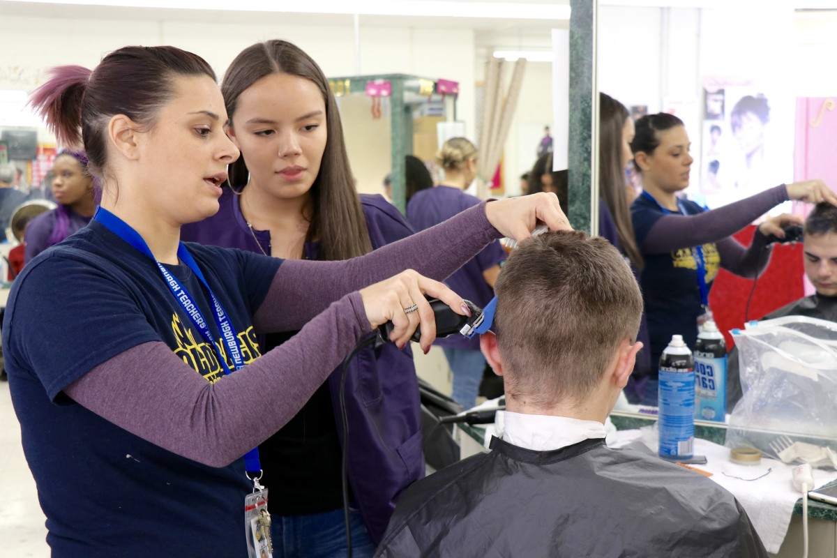 Teacher helps students perfect technique.