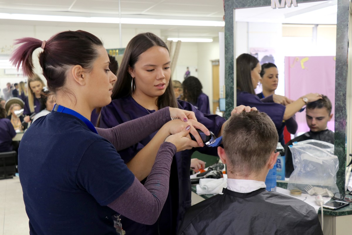 Teacher helps students perfect technique.