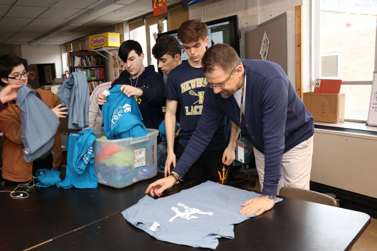 Students looking at shirts and their design from previous events.