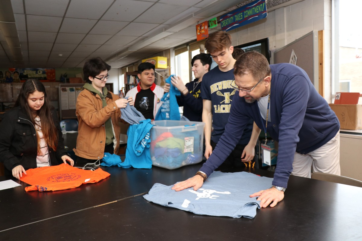 Students looking at shirts and their design from previous events.