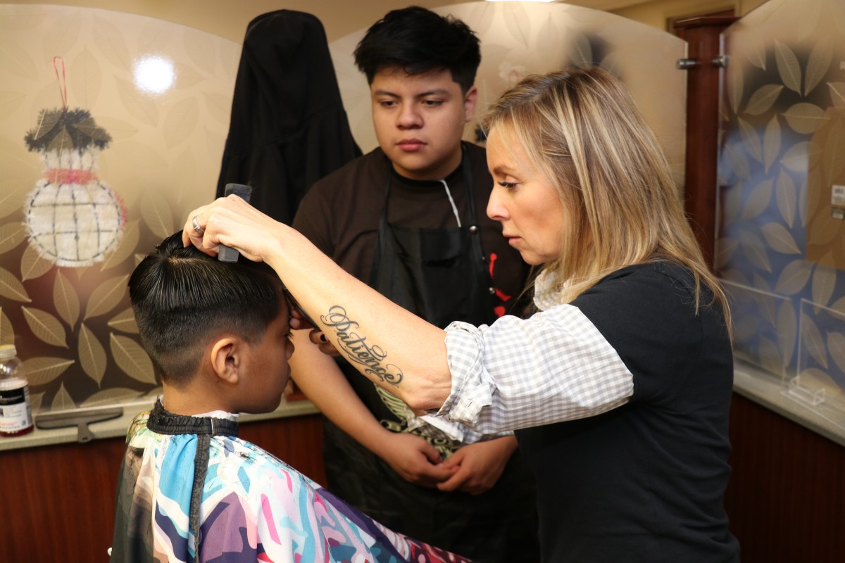 Student cutting hair.