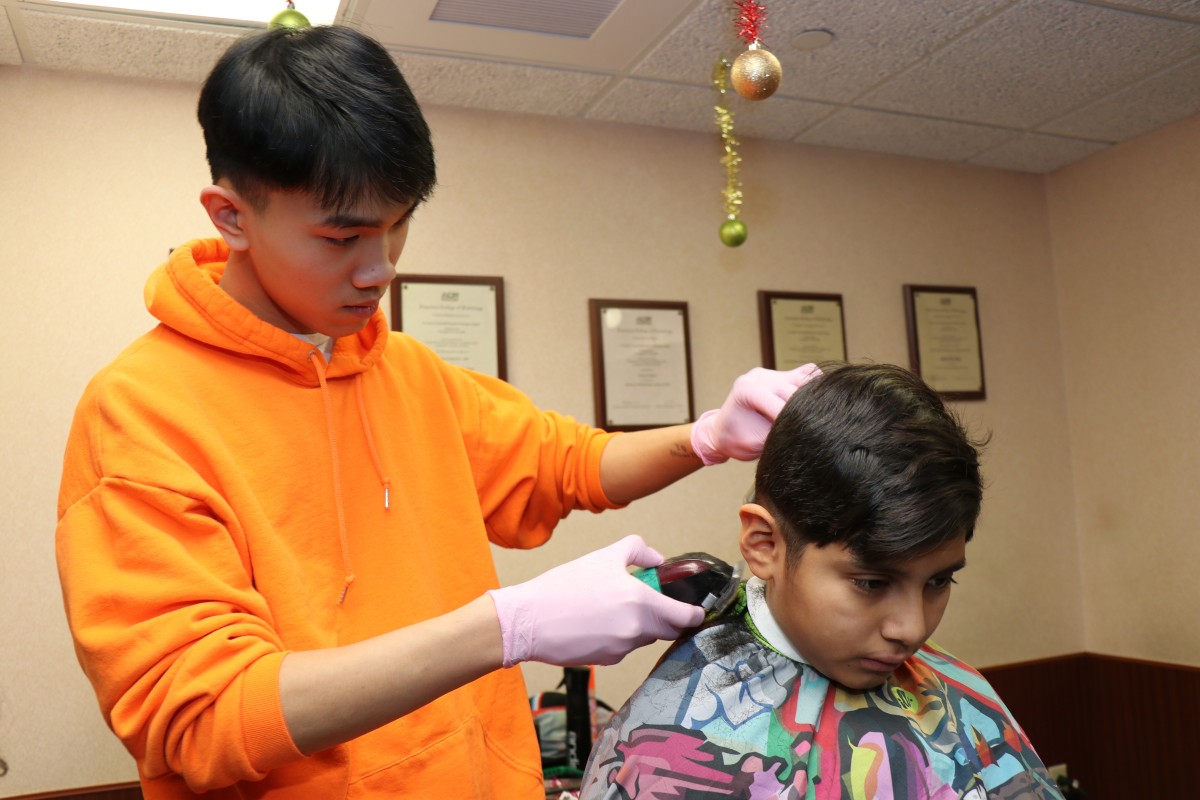 Student cutting hair.