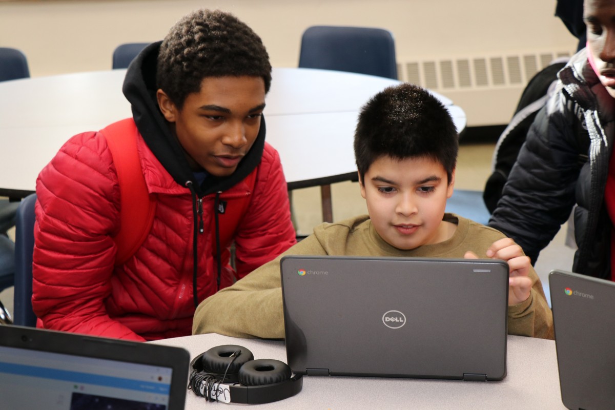 High school scholar teaching elementary scholar.