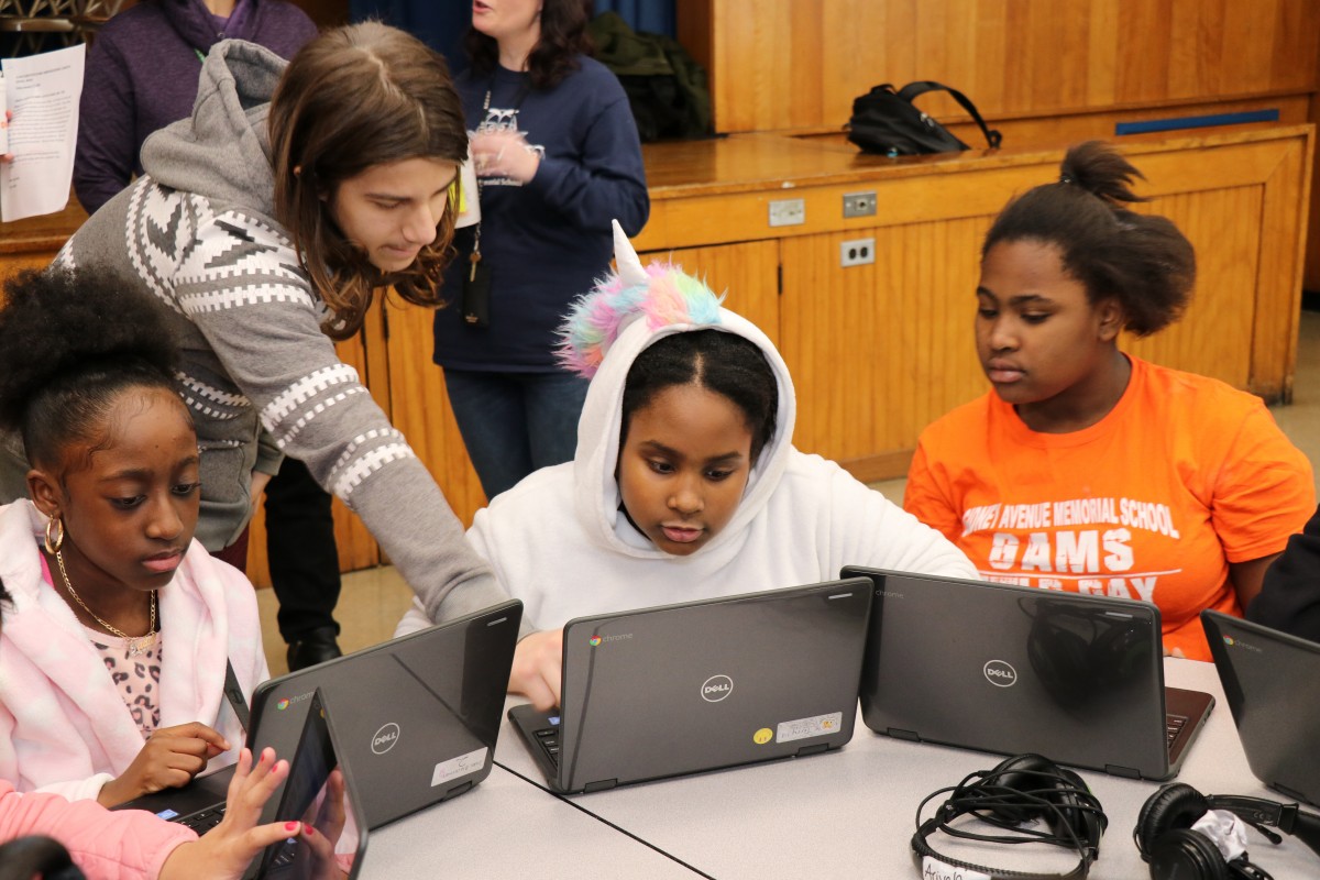 High school scholar teaching elementary scholars.