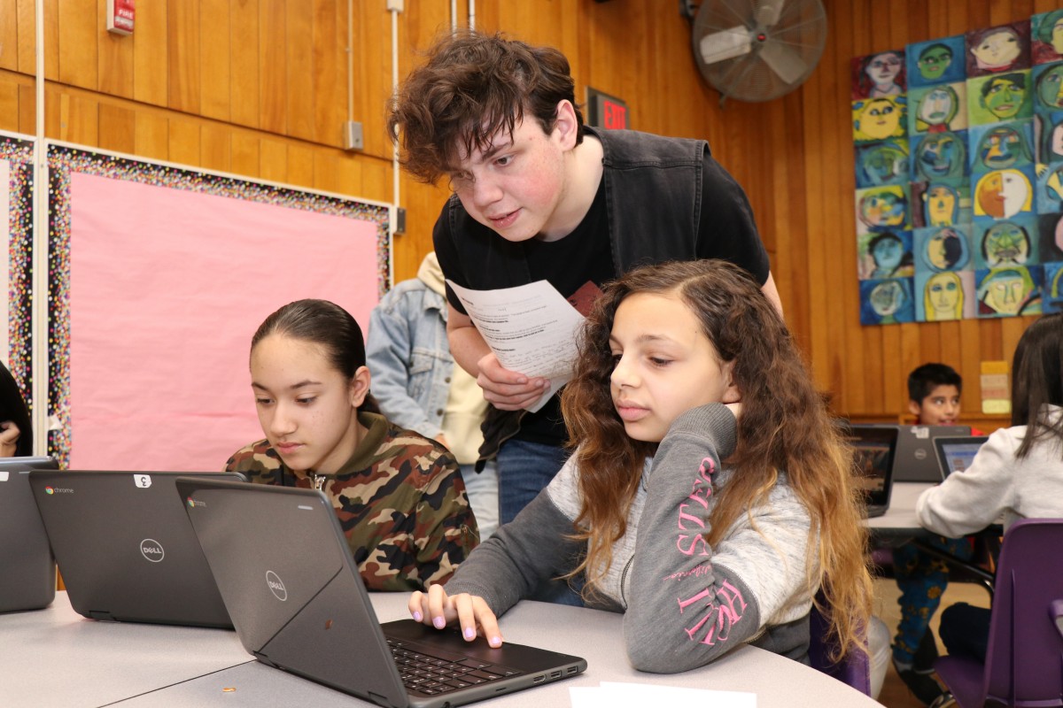 High school scholar teaching elementary scholars.