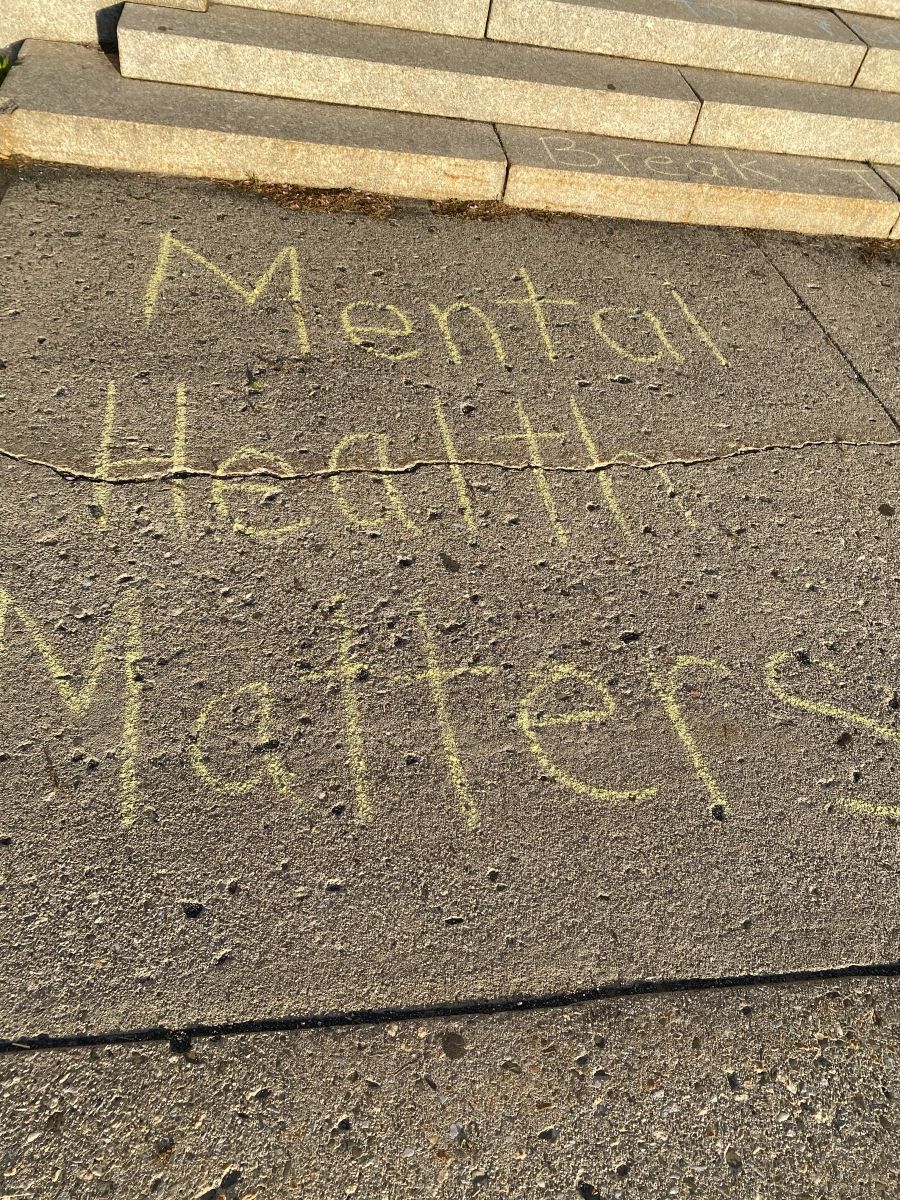 Sidewalk chalk with positive messages about mental health.