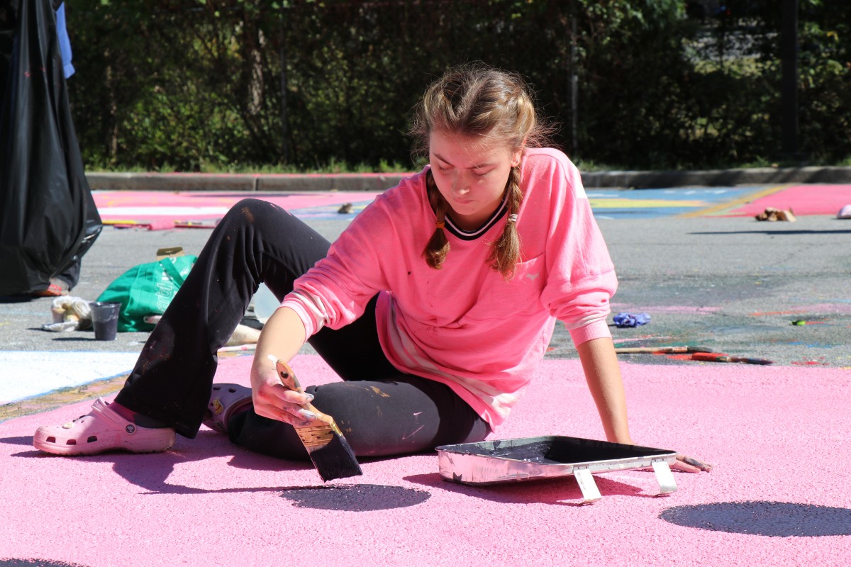 Student painting parking spot.