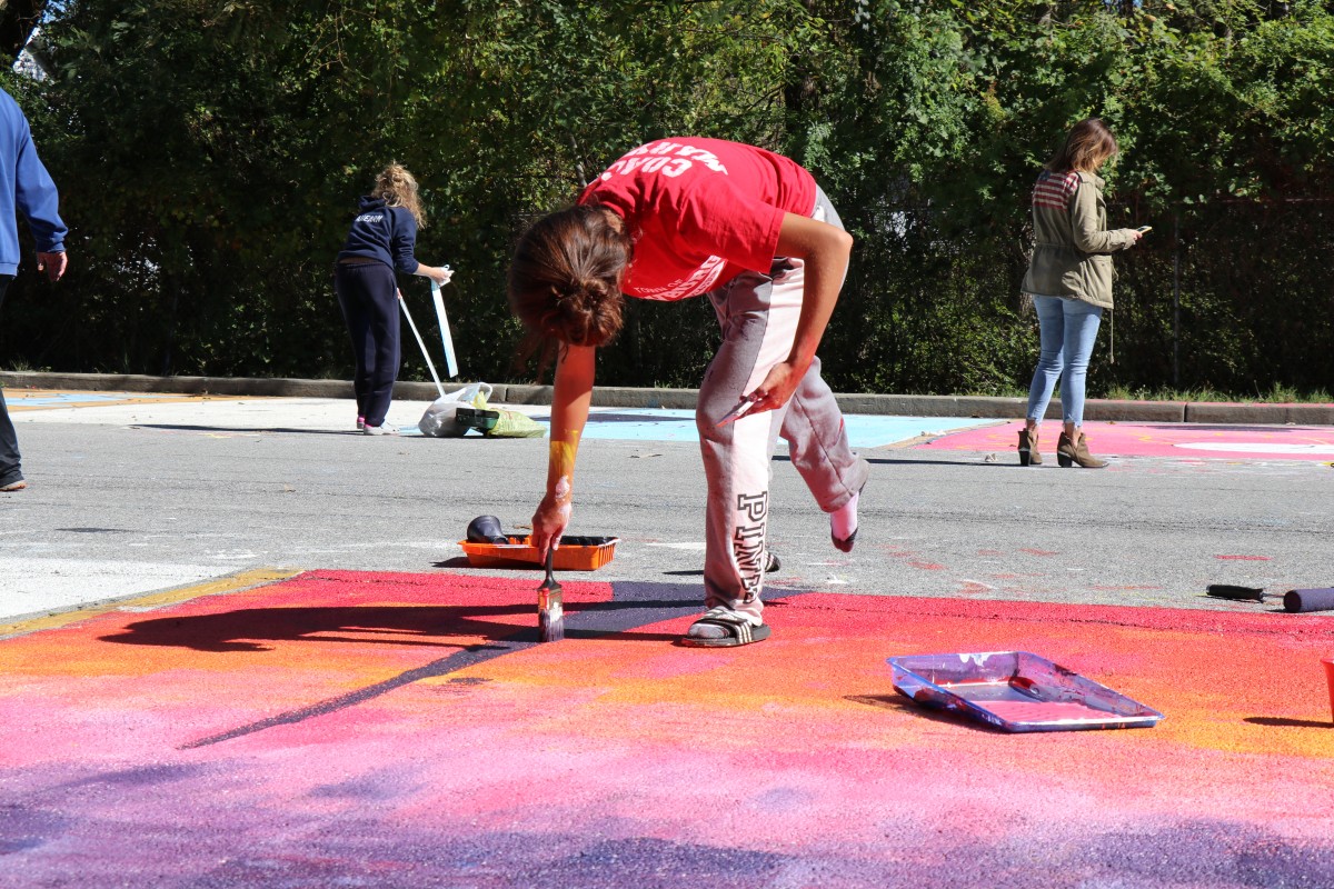 Student painting parking spot.