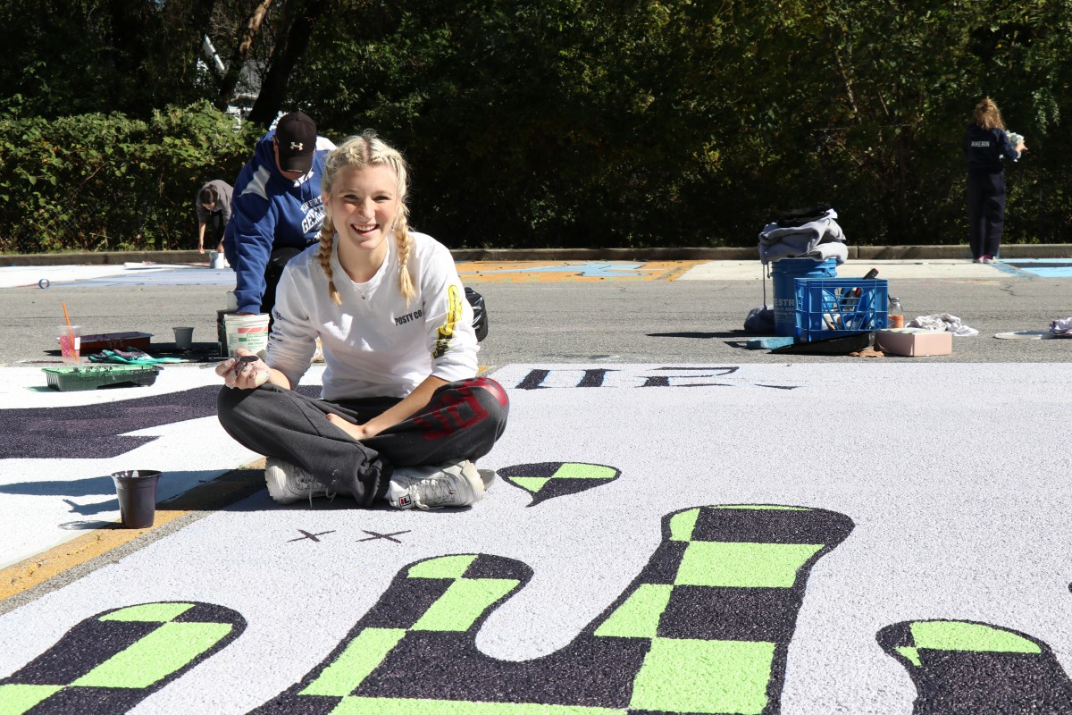 Student painting parking spot.