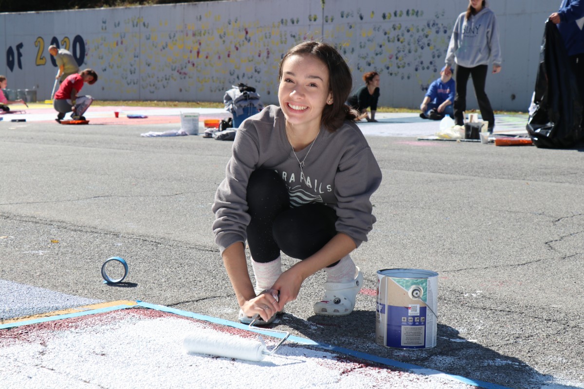 Student painting parking spot.