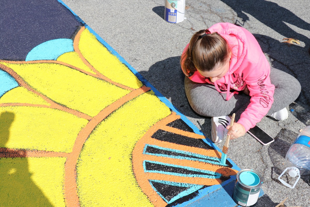 Student painting parking spot.