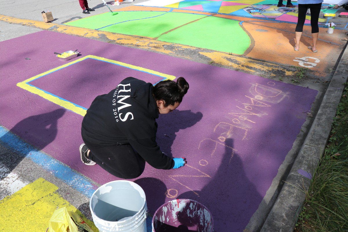 Student painting parking spot.